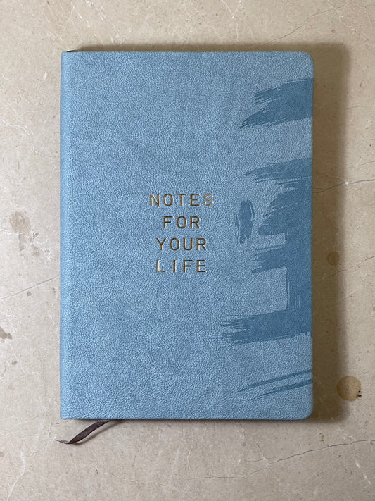 Blue notebook with 'Notes for Your Life' text on a textured surface