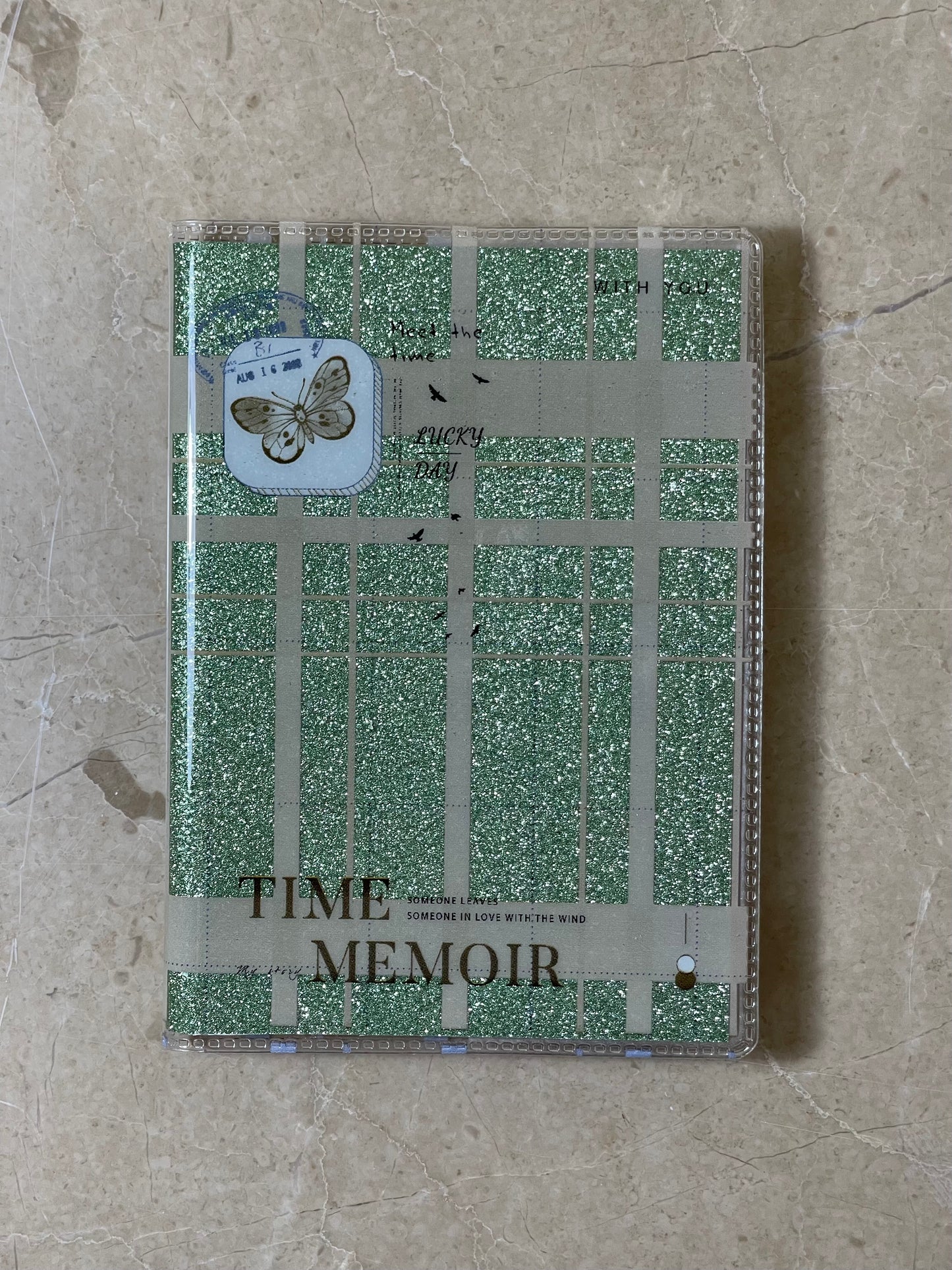 Notebook with green checkered design and 'Time Memoir' text on a beige surface