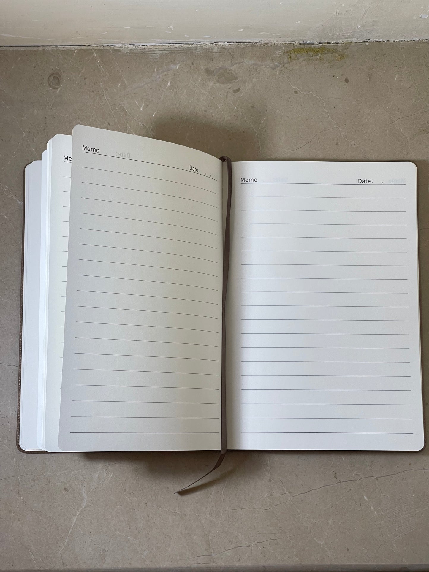 Open notebook with lined pages on a concrete surface