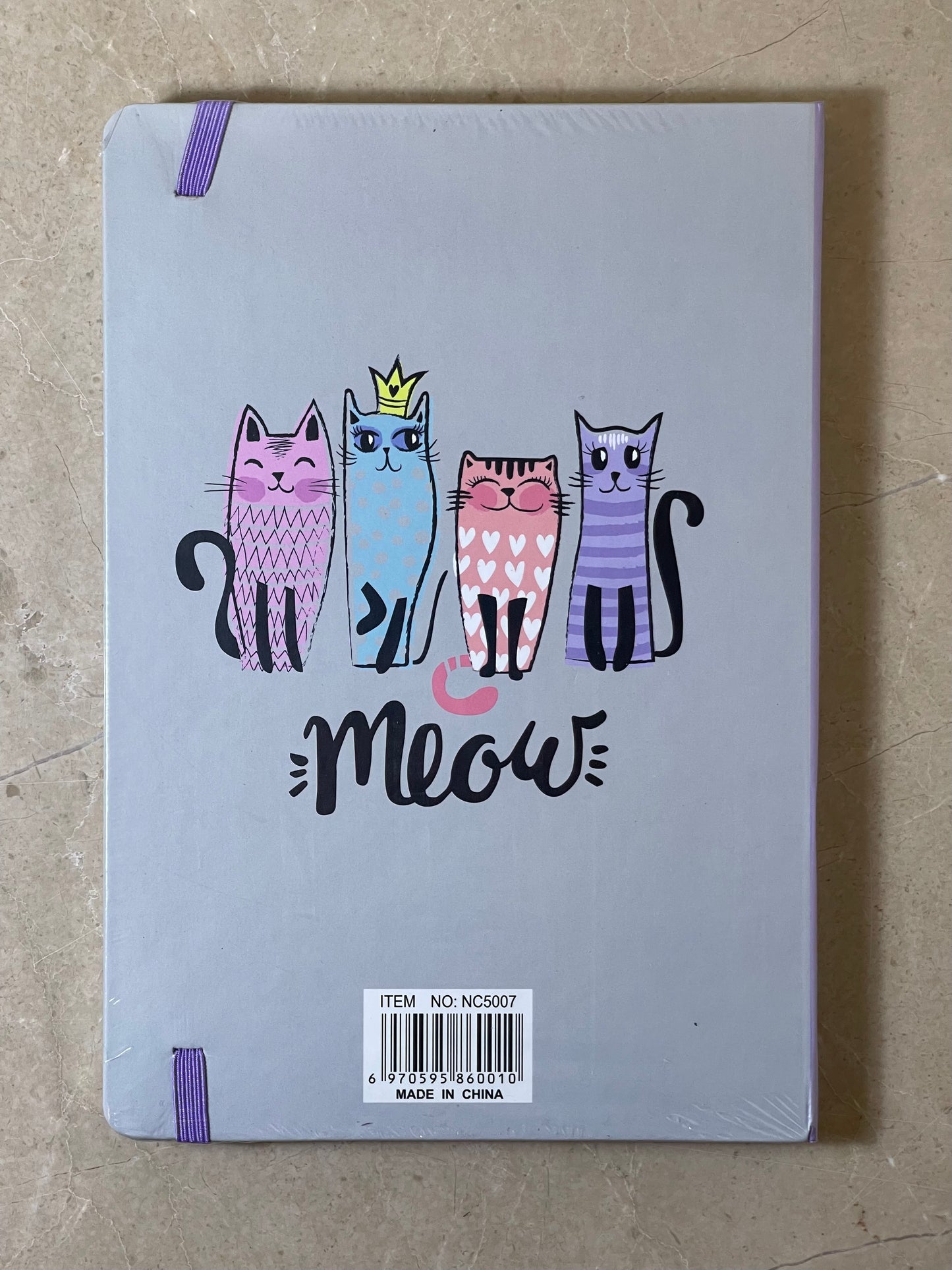 Notebook with cat illustrations and 'Meow' text on a beige surface