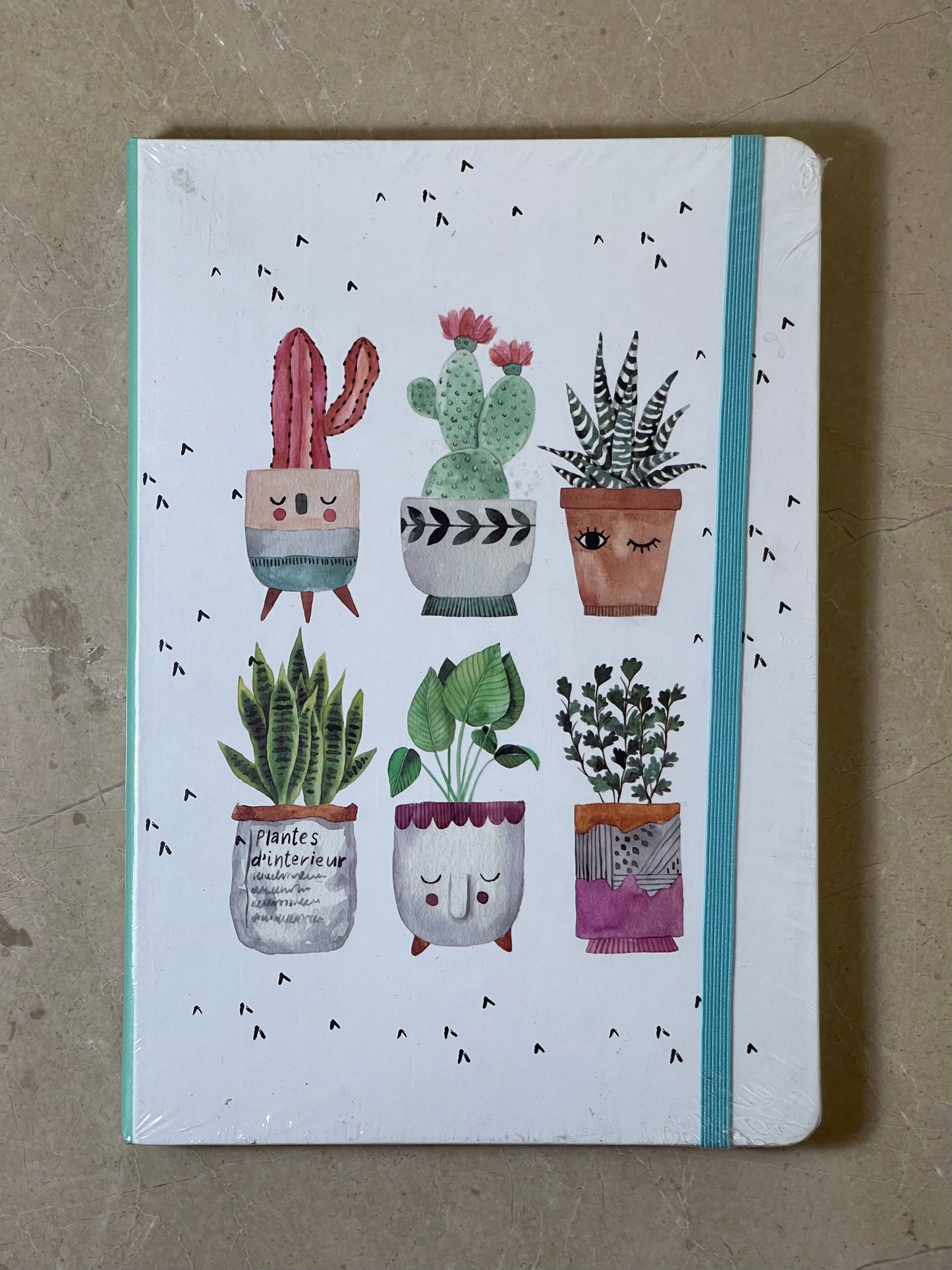 Notebook with illustrations of potted plants on a beige background