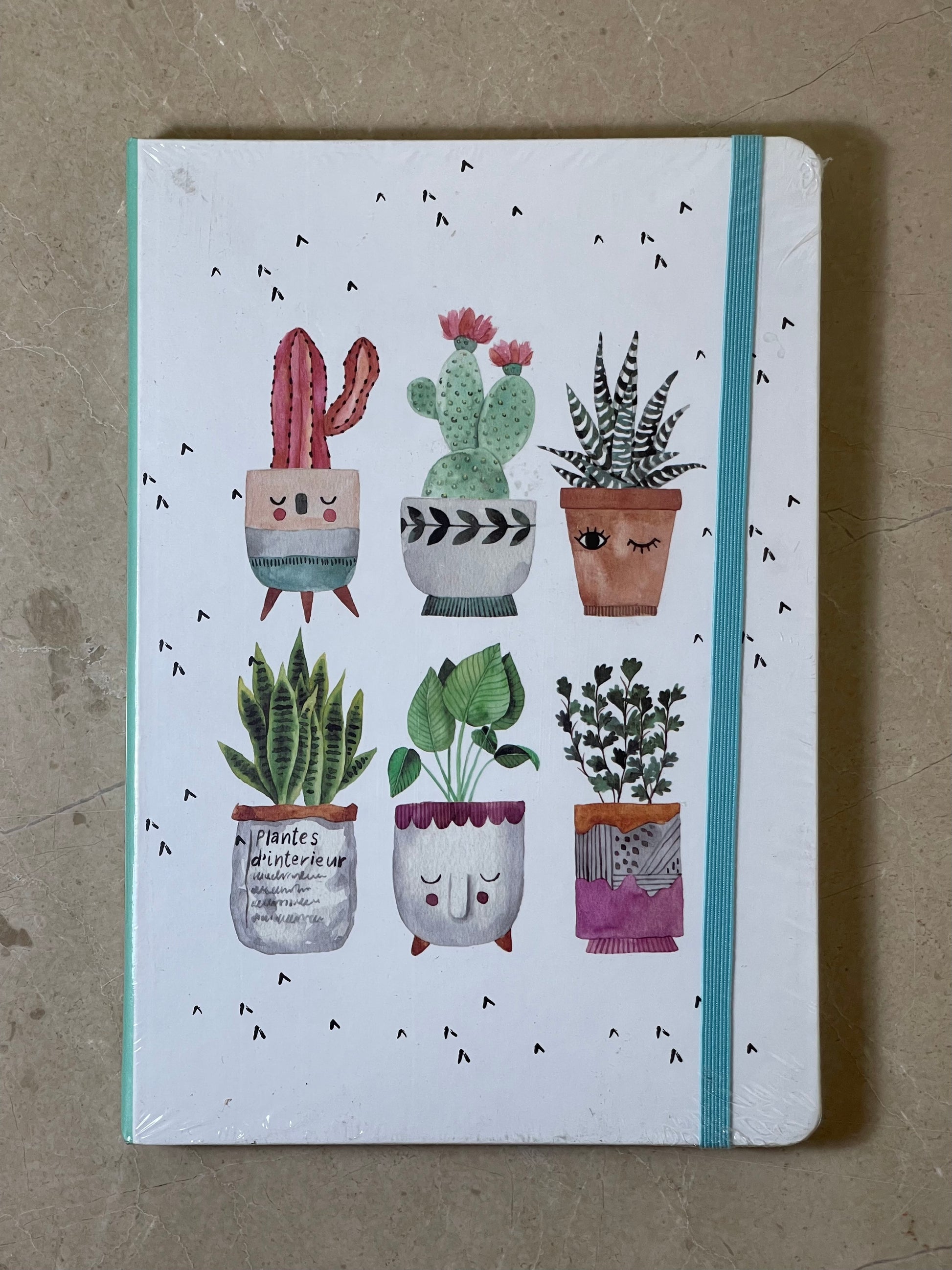 Notebook with illustrations of potted plants on a beige background