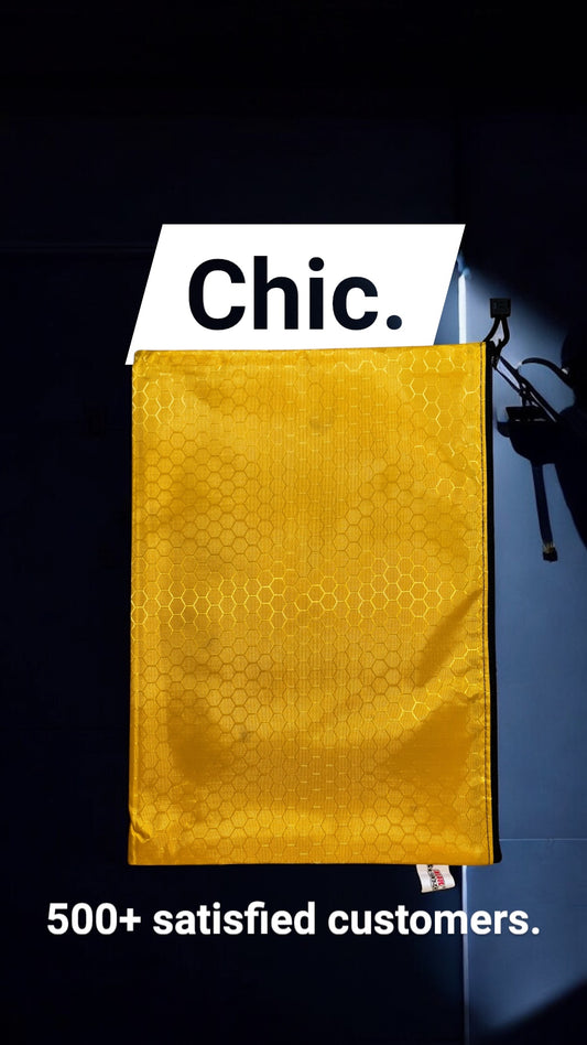 Gold large zipper pouch with 'Chic.' label and text about satisfied customers on a dark background