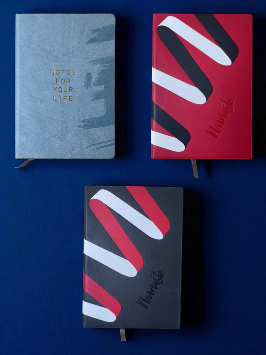 Three notebooks with different designs on a blue background