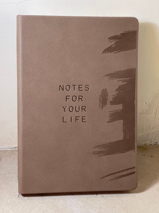 Brown notebook with 'Notes for Your Life' text on a light background